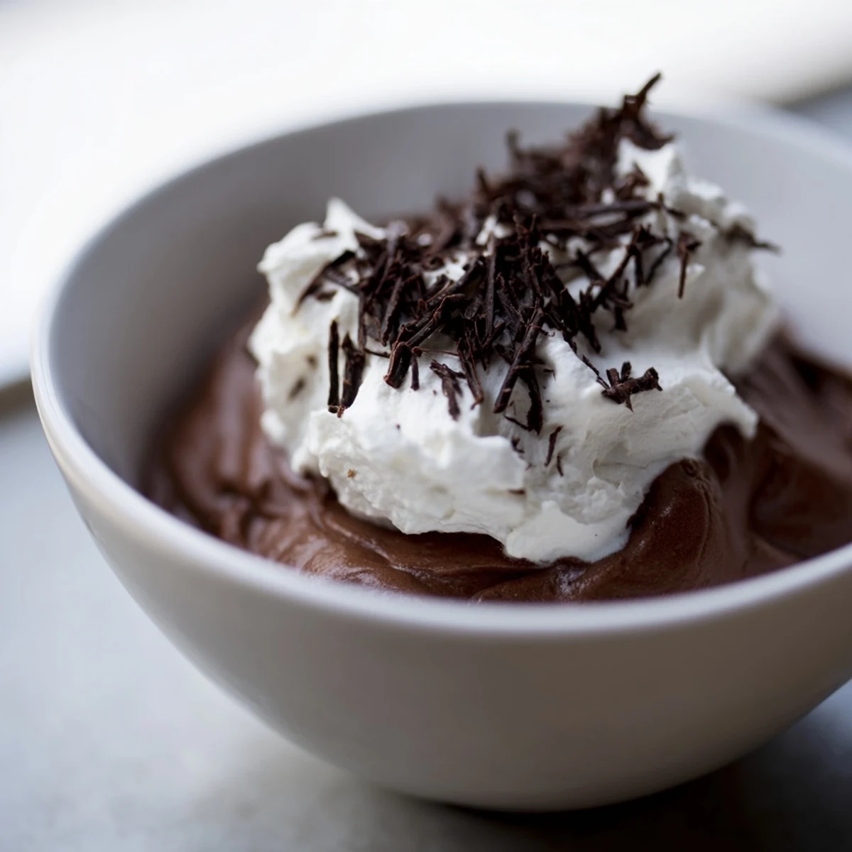 Decadent Chocolate Mousse garnished with fresh berries, showcasing its velvety texture and airy, homemade whipped cream topping.