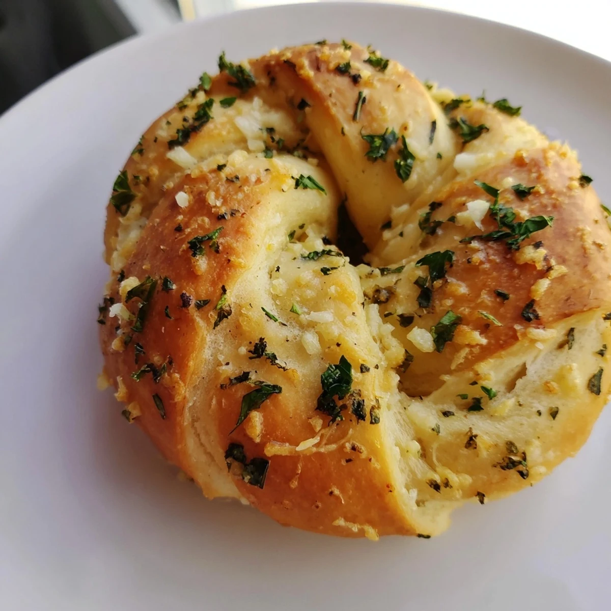 Twelve golden Garlic Parmesan Dough Knots on a baking sheet, brushed with savory garlic butter and sprinkled with parsley.