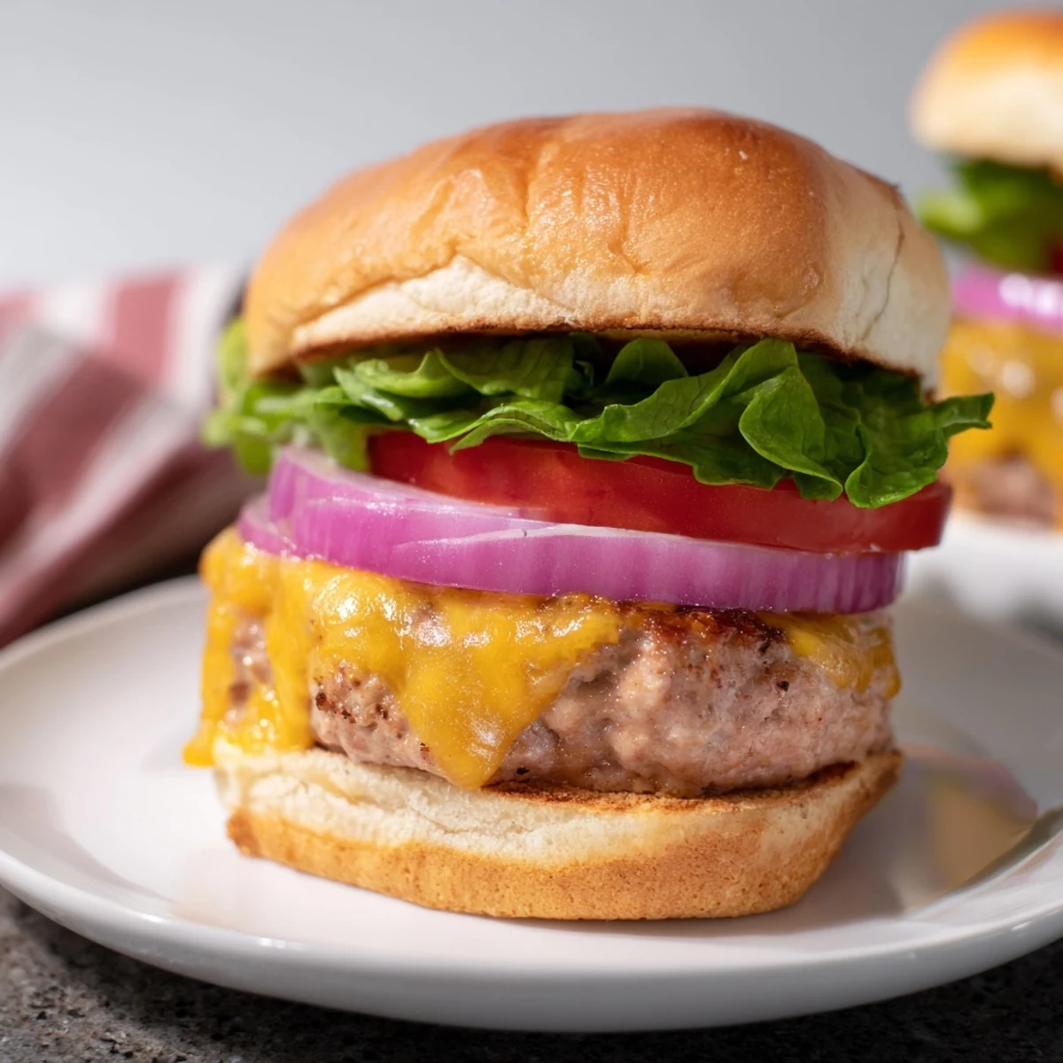 Melty cheddar cheese melts over a juicy turkey burger patty on a toasted bun with lettuce and tomato.