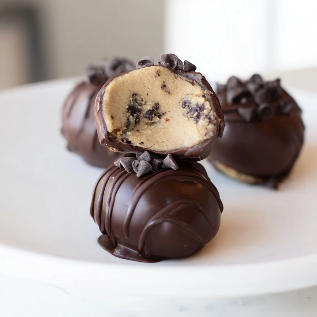 Chocolate Chip Cookie Dough Truffles sit on a cooling rack with powdered sugar dusting.