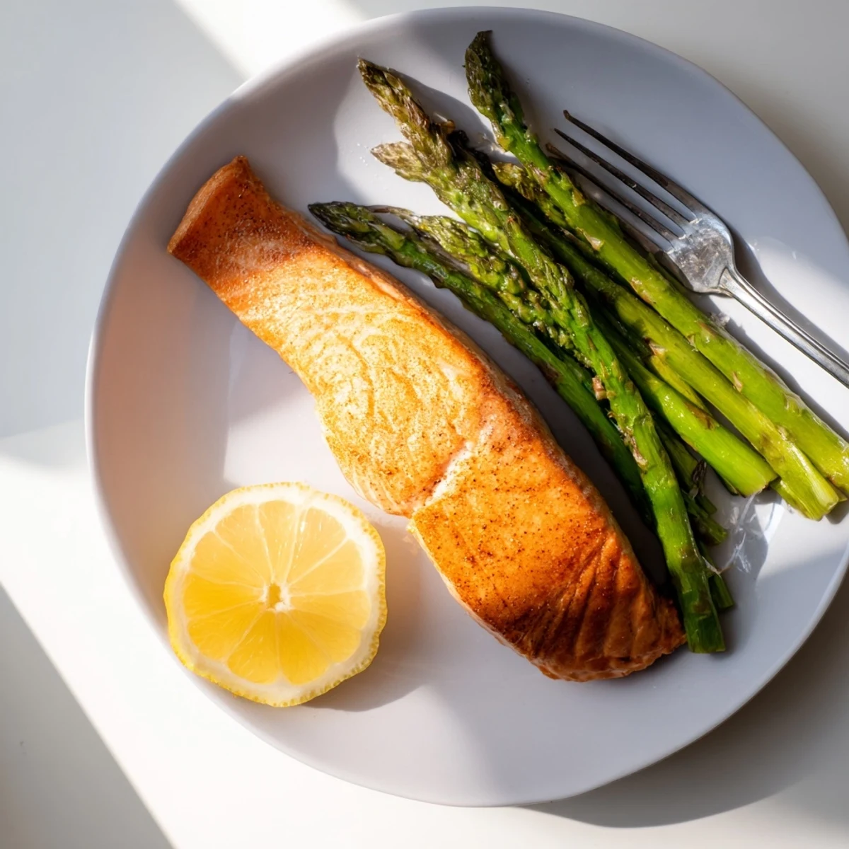 Close-up on flaky fish and lightly charred greens in this easy Crispy Air Fryer Salmon with Asparagus dinner.