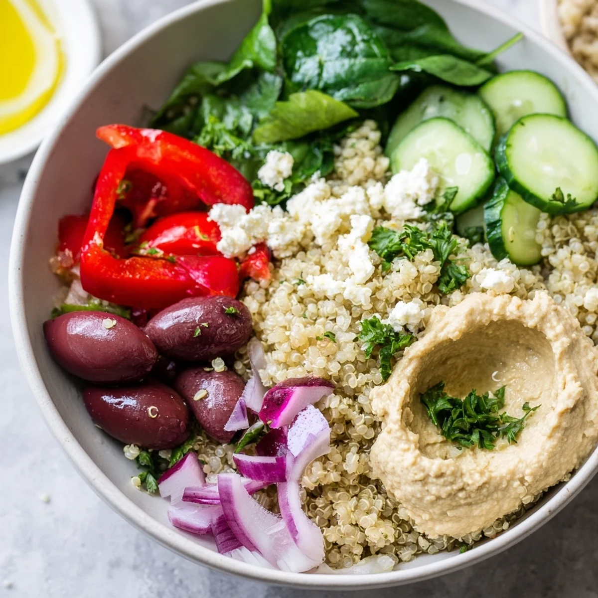 Healthy Mediterranean Quinoa Bowl with fluffy quinoa, hummus, feta, and fresh parsley garnish ready to eat.