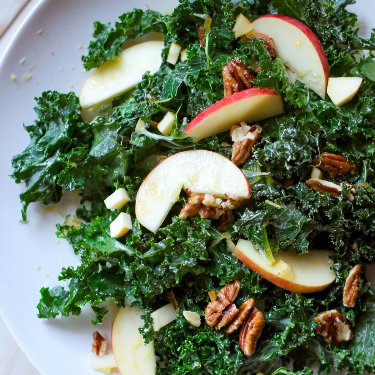 Bright winter kale salad with apples, cheddar, and crunchy pecans, perfect for a healthy vegetarian side dish.