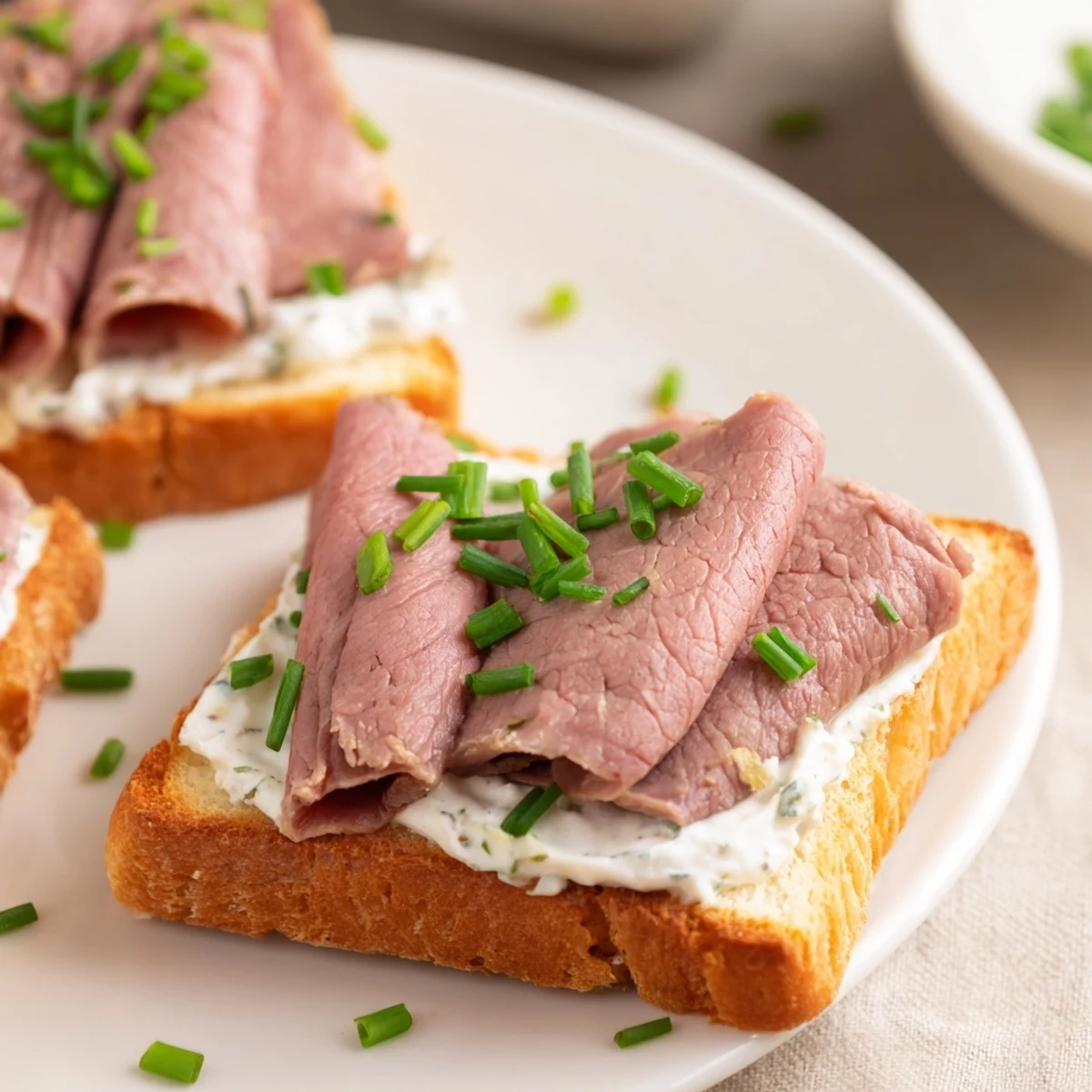 Golden homemade toast points layered with savory roast beef and a zesty horseradish cream cheese spread for an elegant bite.  