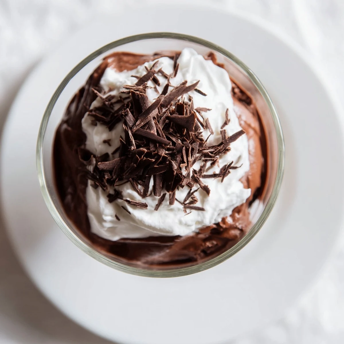 Layered Chocolate Mousse with Whipped Cream topped with shaved chocolate, ready to serve.
