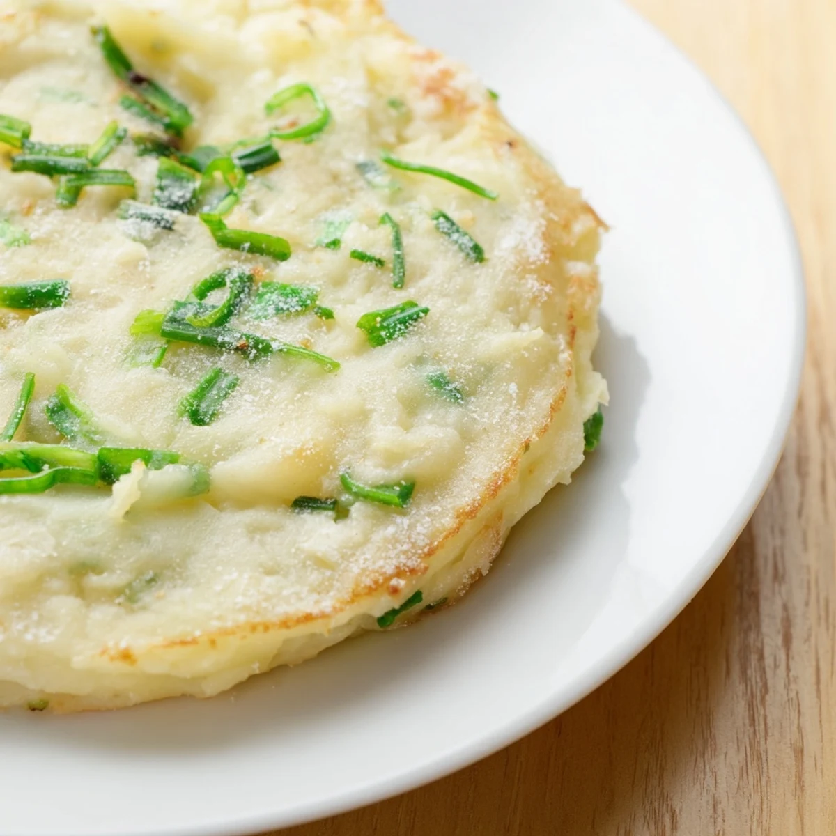A serving of warm Irish Potato Cakes with Scallions topped with melting butter, perfect for a savory breakfast or snack.