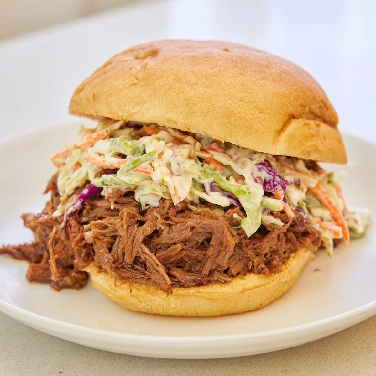 Close-up of tender pulled beef brisket sliders with BBQ sauce and crunchy slaw, ready for a game day party platter.
