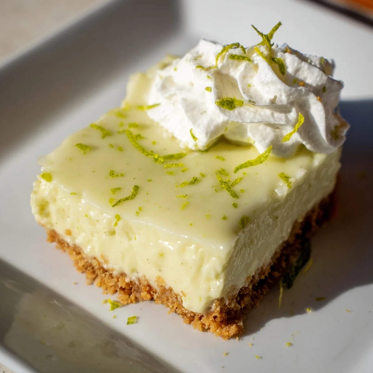Key Lime Pie Bars sliced into neat squares, showing the tangy filling and buttery graham cracker crust on a marble board.
