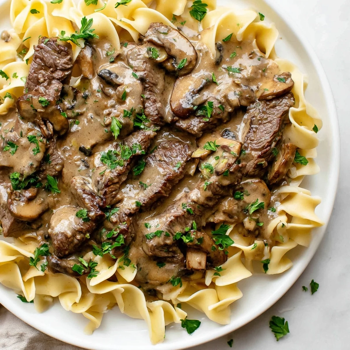 Creamy Beef Stroganoff with Egg Noodles featuring tender beef strips and mushrooms in a rich sauce.