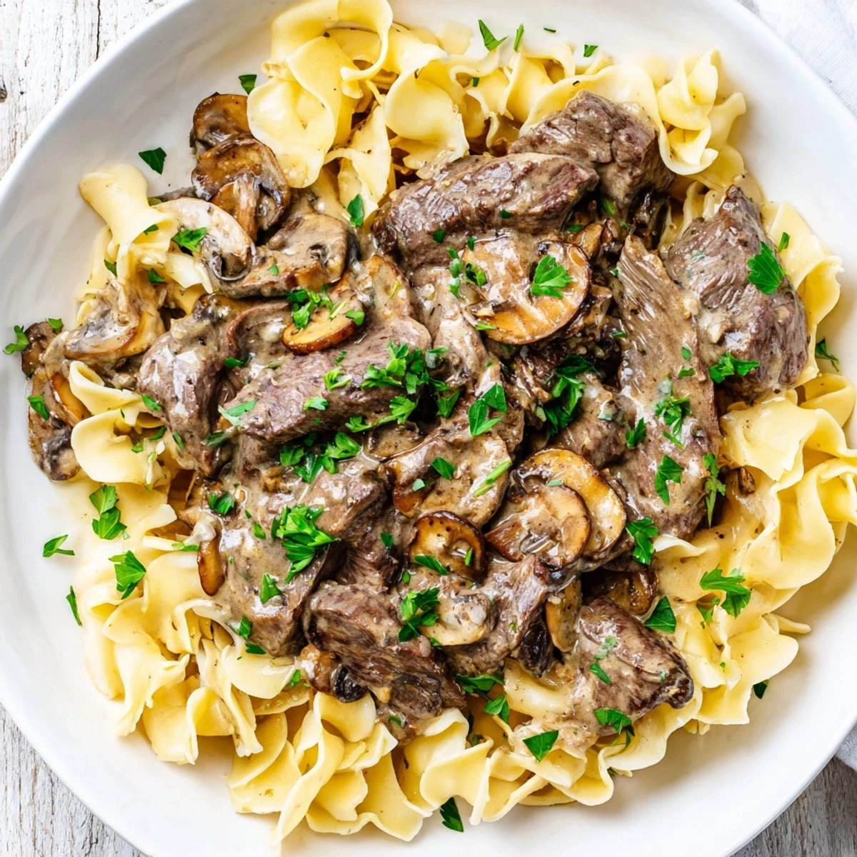 Hearty Beef Stroganoff with Egg Noodles served steaming hot, garnished with fresh parsley for a family meal.