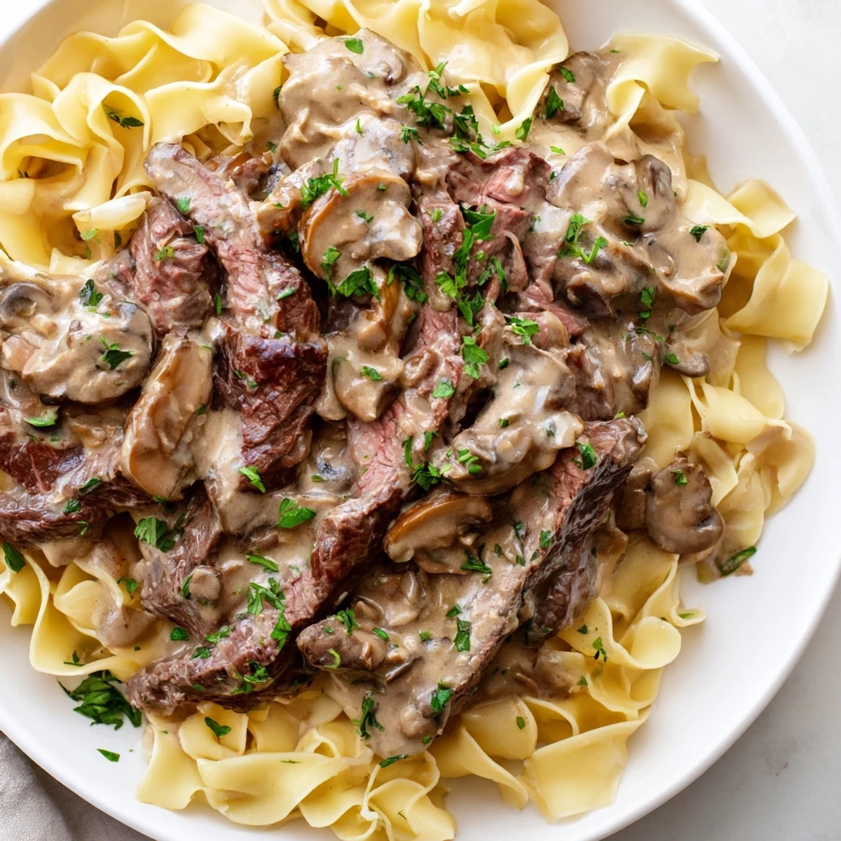 Savory Beef Stroganoff with Egg Noodles in a creamy mushroom sauce, ready to serve with a side salad.