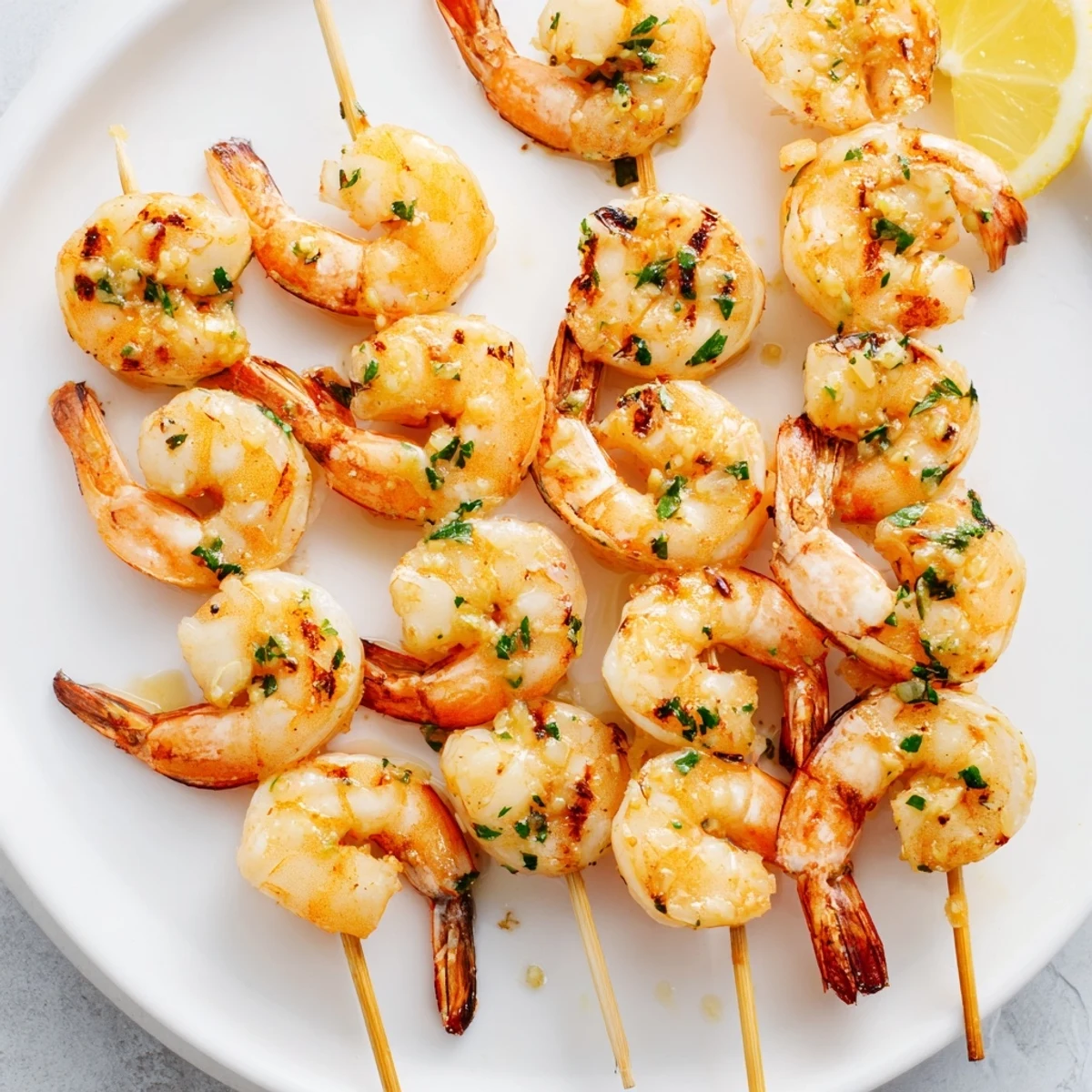 Golden-brown Lemon Garlic Shrimp Skewers sizzling on the grill, showcasing juicy pink shrimp with charred edges.