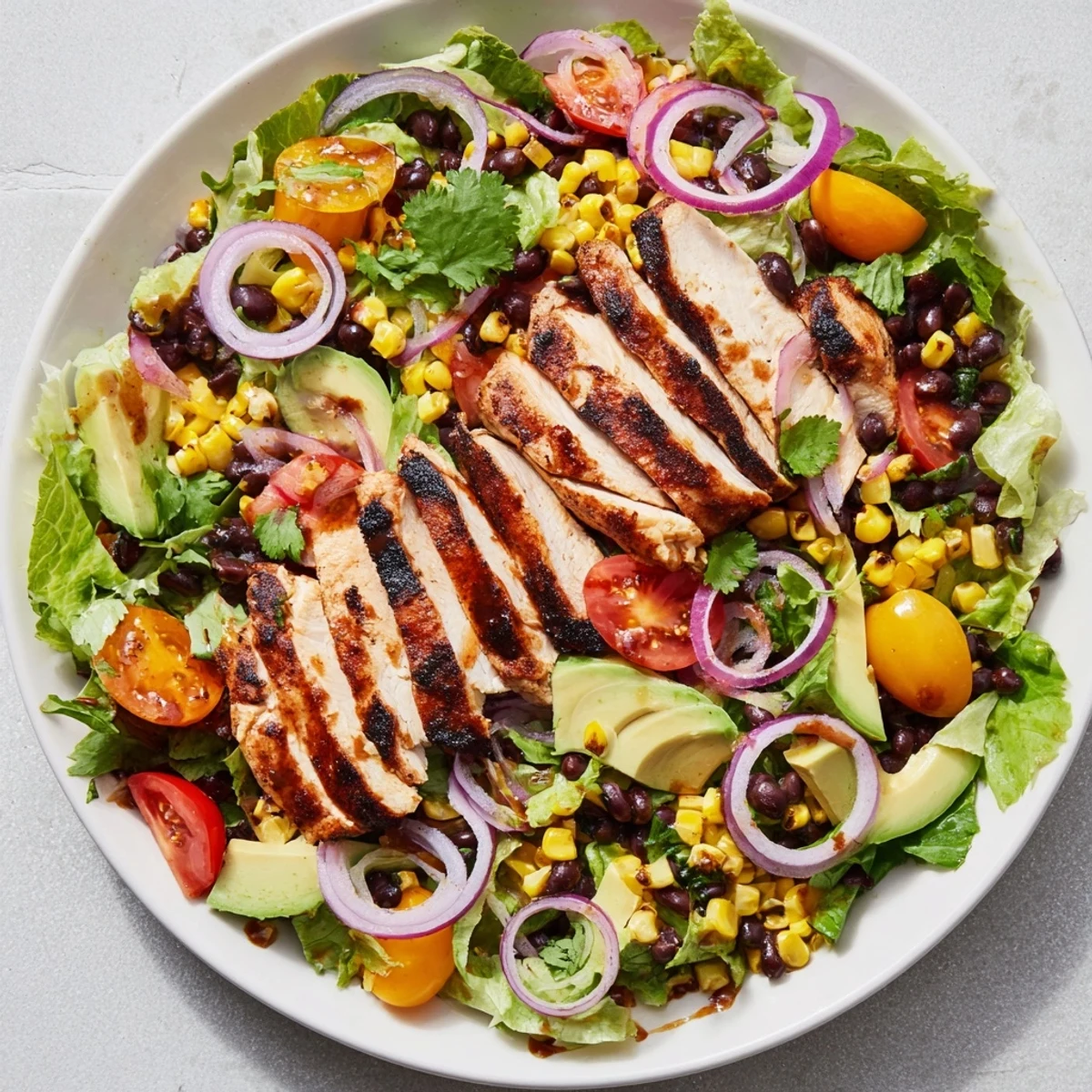 A vibrant Chipotle Lime Chicken Salad with grilled chicken, black beans, corn, and avocado on a bed of greens.