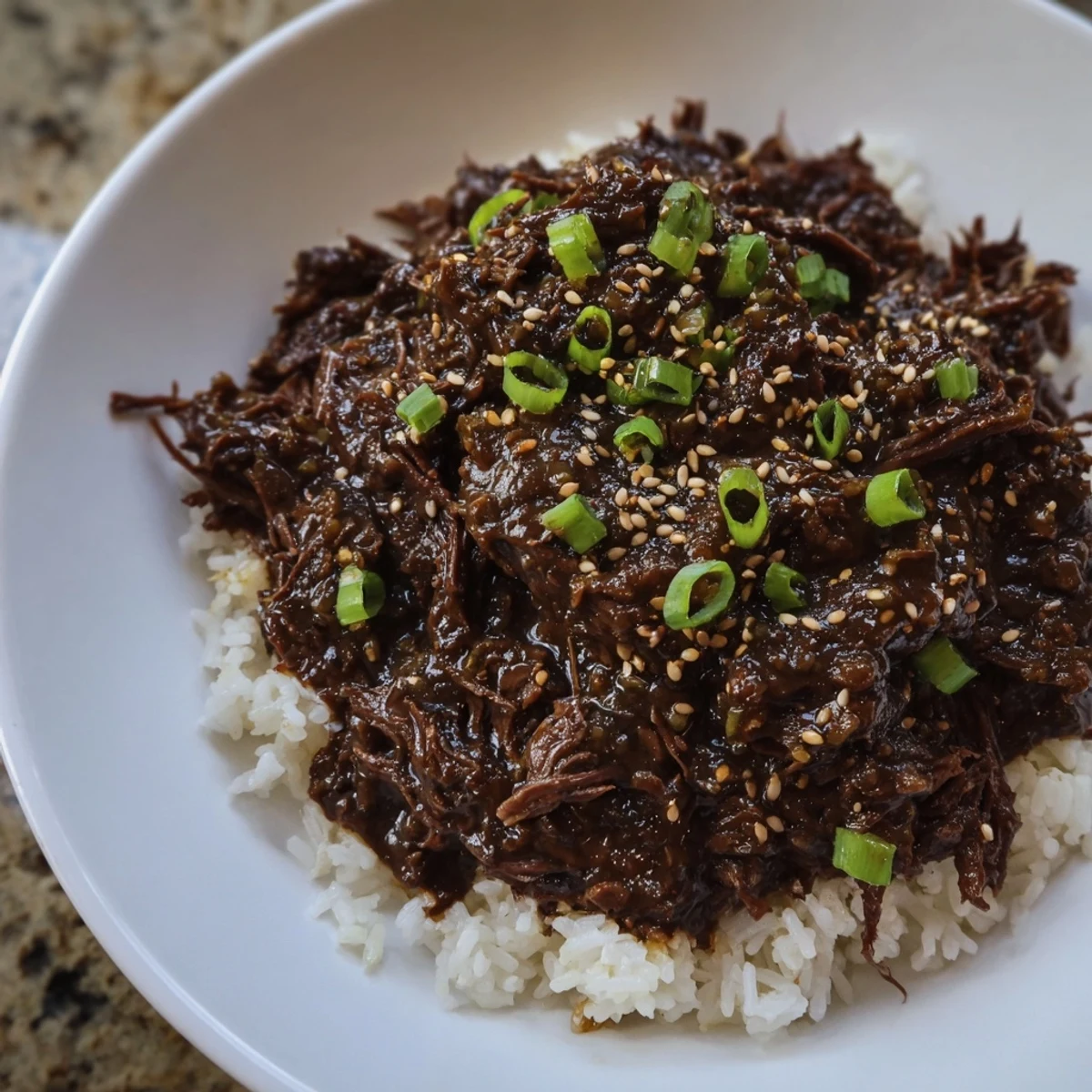 Crock Pot Korean Beef simmered in a rich, aromatic sauce served over fluffy rice with a sprinkle of sesame seeds.