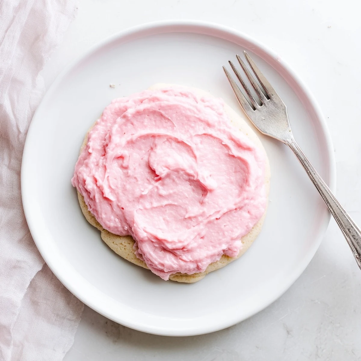 Freshly baked Crumbl Sugar Cookies with thick, soft centers and creamy pink almond frosting are arranged on a wire rack for a party dessert spread.