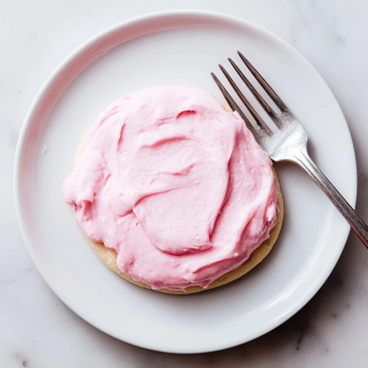 Stack of warm Crumbl Sugar Cookies topped with swirls of pink almond icing, served on a rustic wooden board for a family gathering.