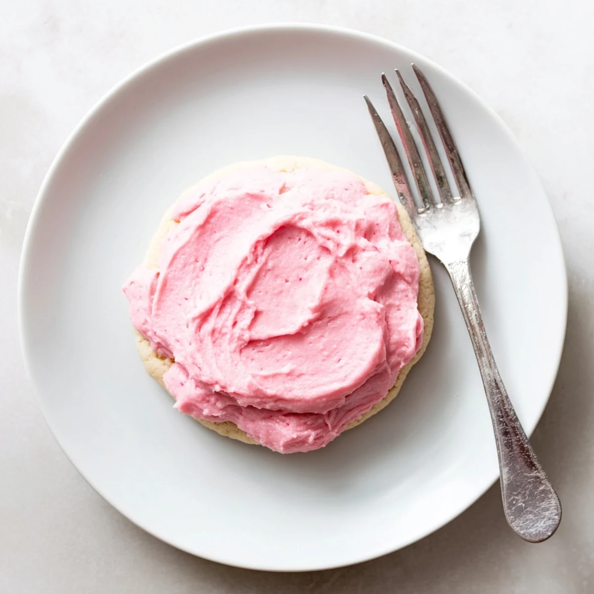 Close-up of a Crumbl Sugar Cookie showing a thick, bakery-style texture and smooth pink almond frosting, perfect for sweet celebrations.