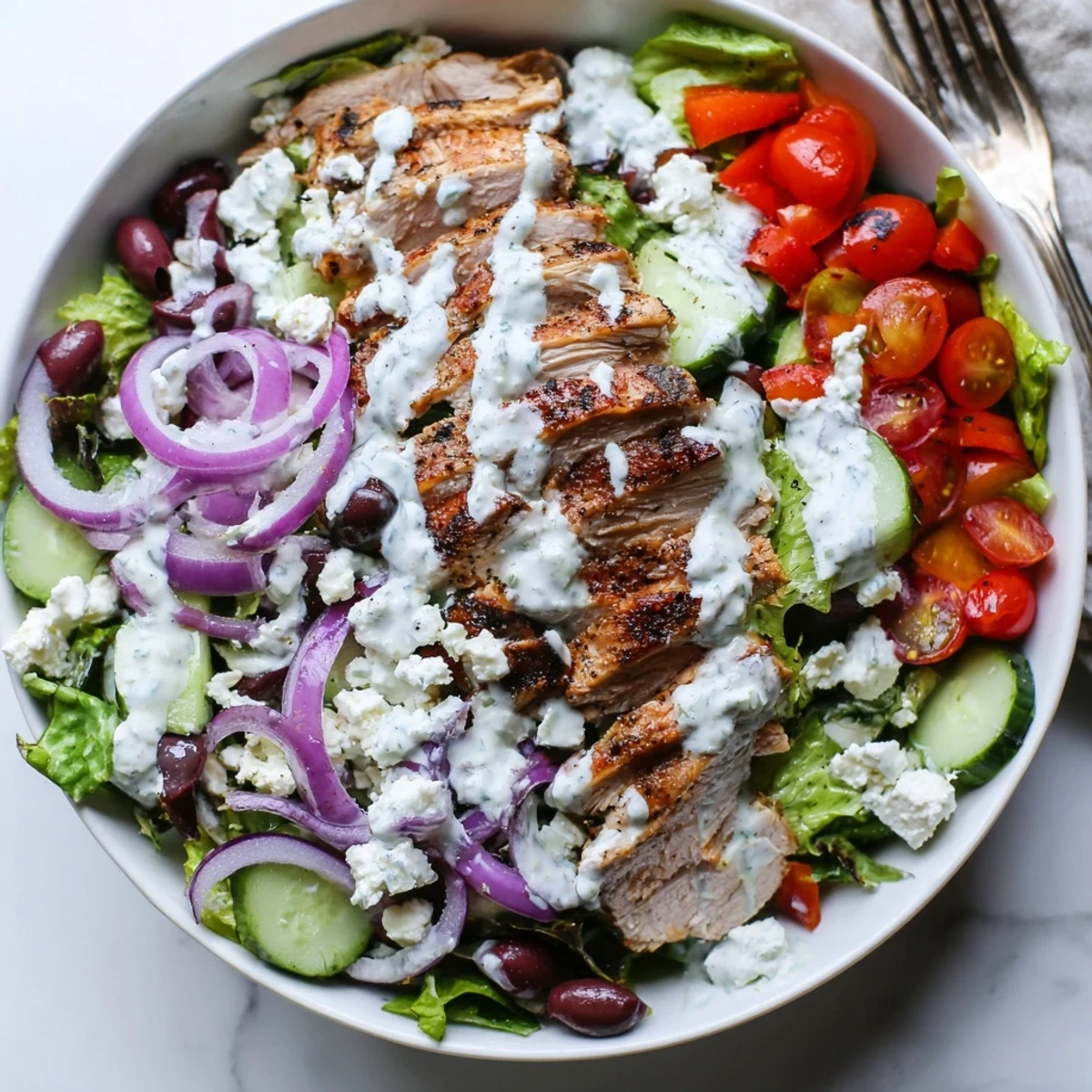 A close-up view of Tzatziki Chicken Salad showcasing tender meat, colorful vegetables, and rich dressing for a light meal.