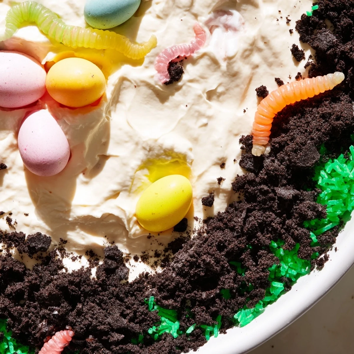 Easy no-bake Easter Dirt Cake Casserole layered with chocolate cookies, vanilla pudding, and whimsical gummy worms.