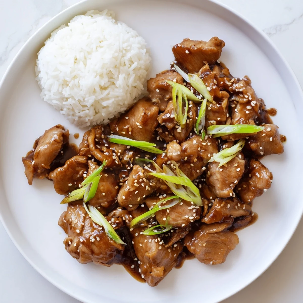Tender chicken thighs simmered in a rich brown sugar ginger sauce for this Mongolian chicken dish