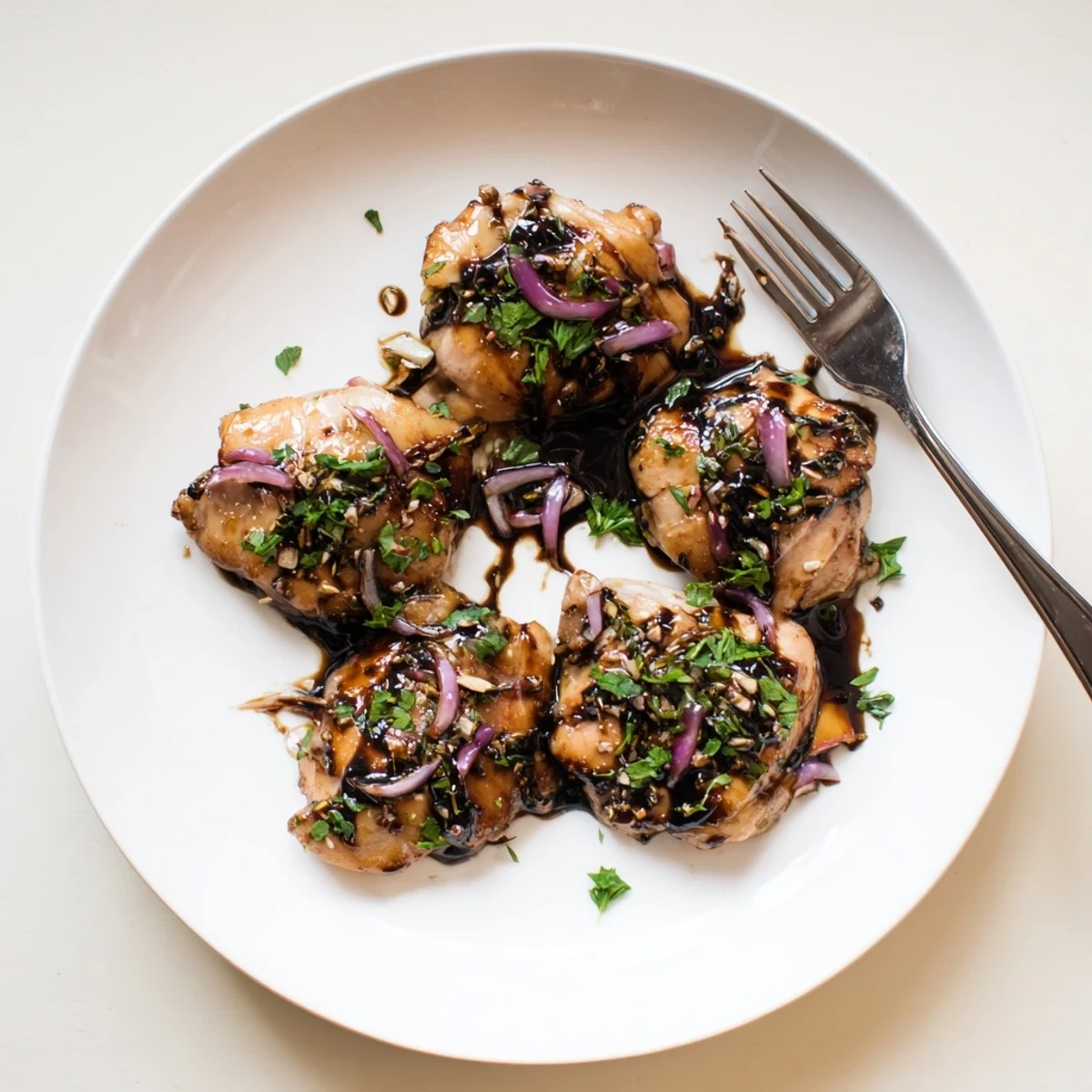 Succulent balsamic chicken plated over fluffy rice with fresh parsley garnish