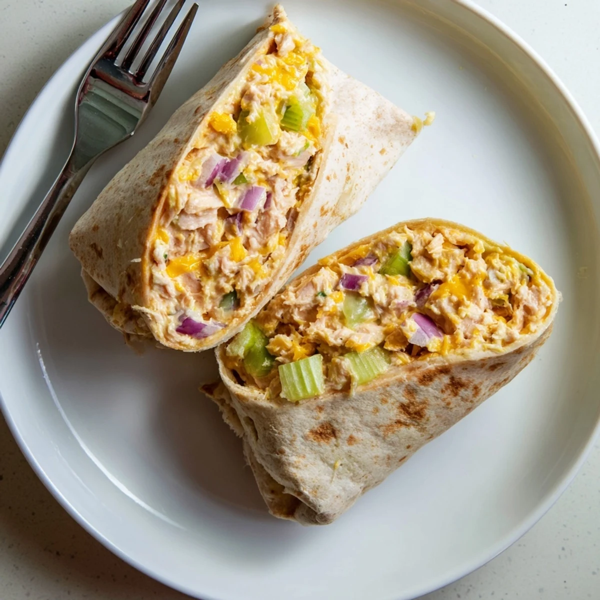 Warm flour tortilla wrapped around cheesy tuna mixture grilled to crispy golden brown perfection