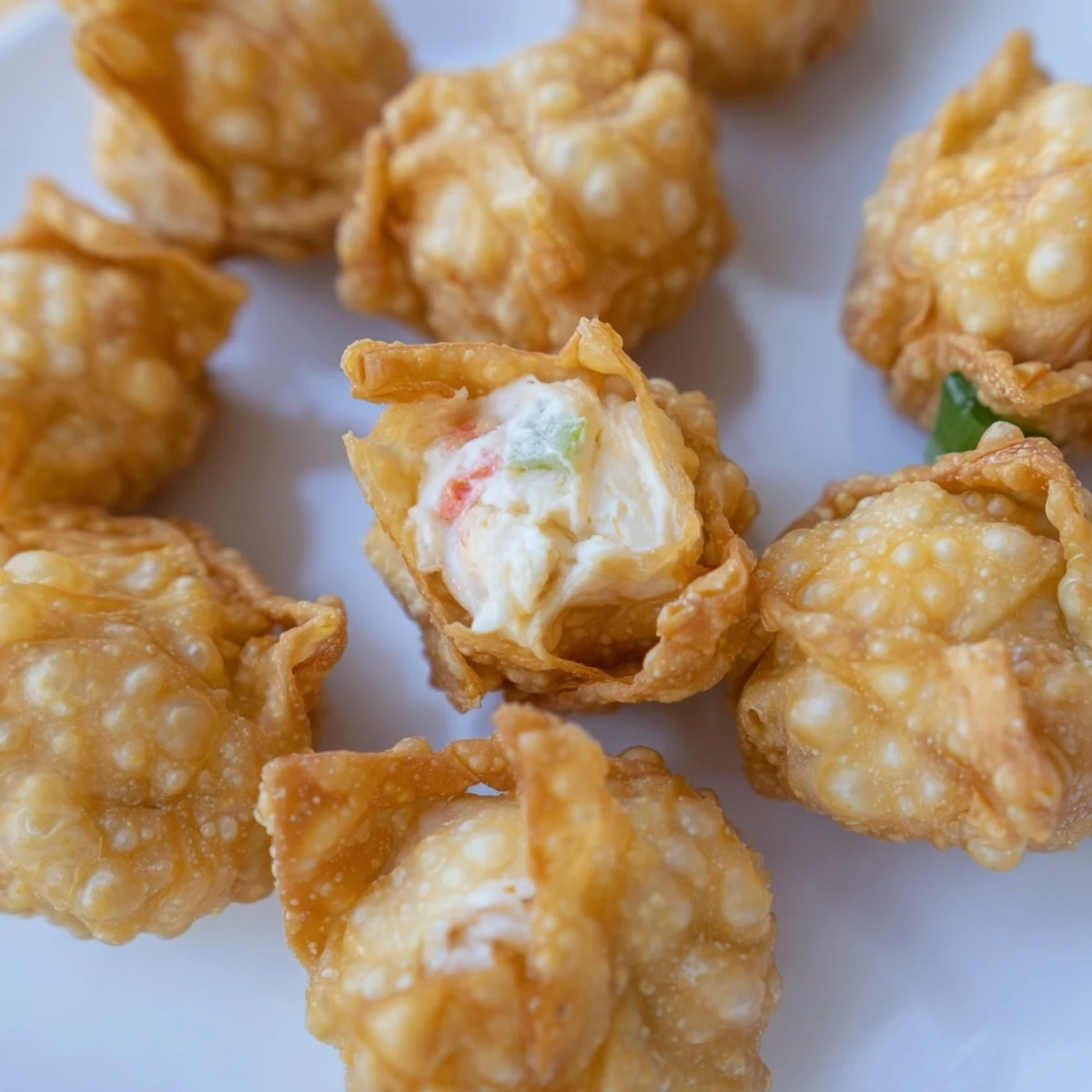 Golden brown Crab Rangoon Bombs featuring crispy fried wonton wrappers stuffed with creamy crab and cream cheese filling