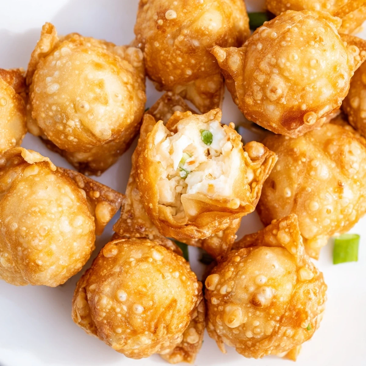 Close-up of golden Crab Rangoon Bombs with flaky crispy exterior and savory crab cheese center visible inside