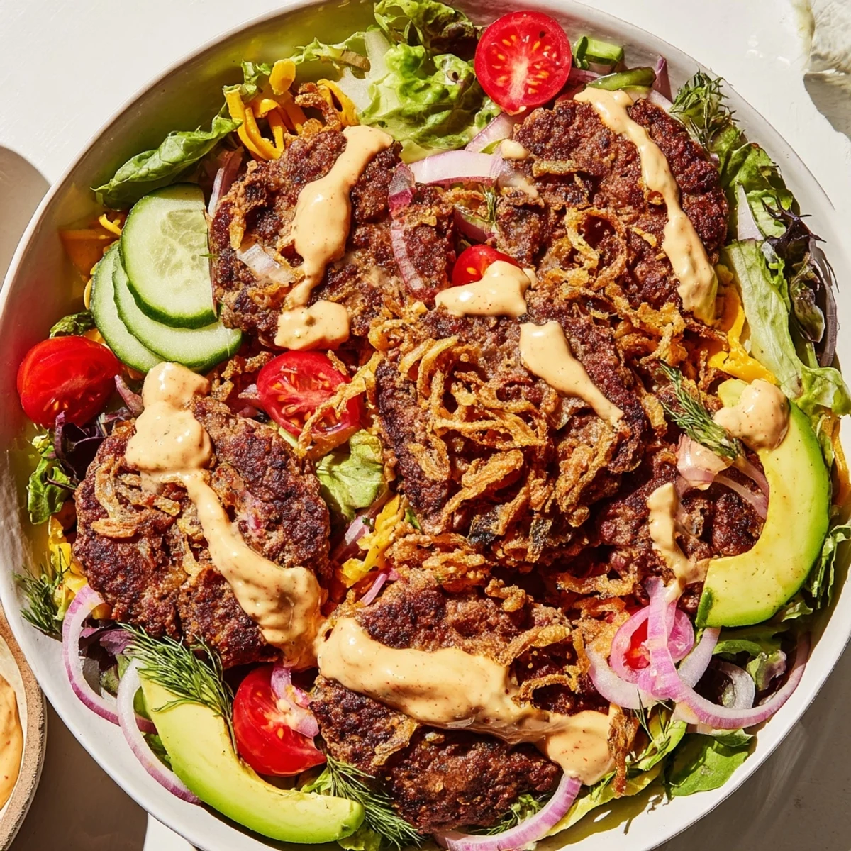 Deconstructed American smash burger bowl layered with crispy beef, fresh vegetables, and savory homemade dressing
