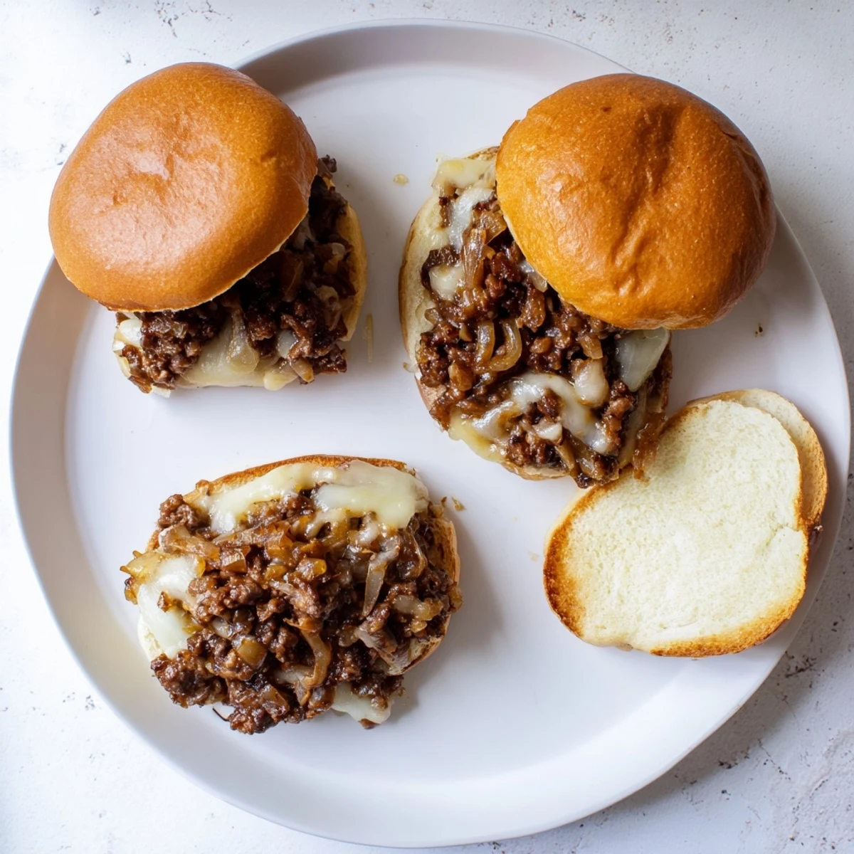 Hearty sloppy Joe sandwich topped with melted provolone and sweet caramelized onions on a golden bun