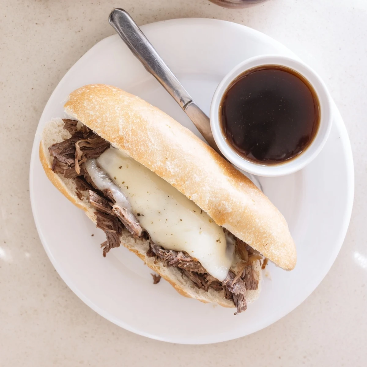 Slow-cooked Crockpot French Dip Sandwiches served with savory au jus dipping sauce for a hearty family dinner