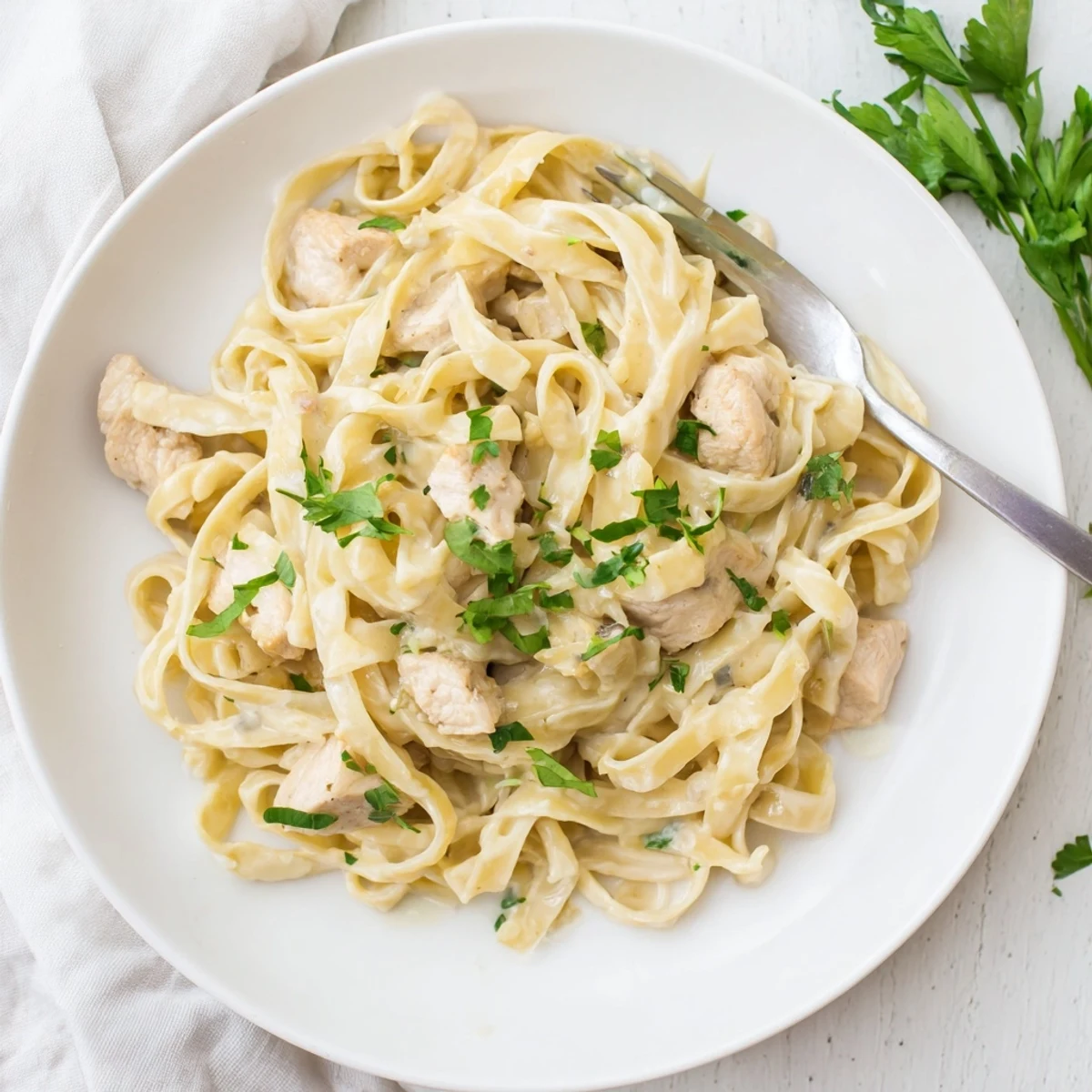 Creamy Instant Pot chicken alfredo featuring tender pasta pieces in a rich parmesan garlic sauce with golden chicken bites