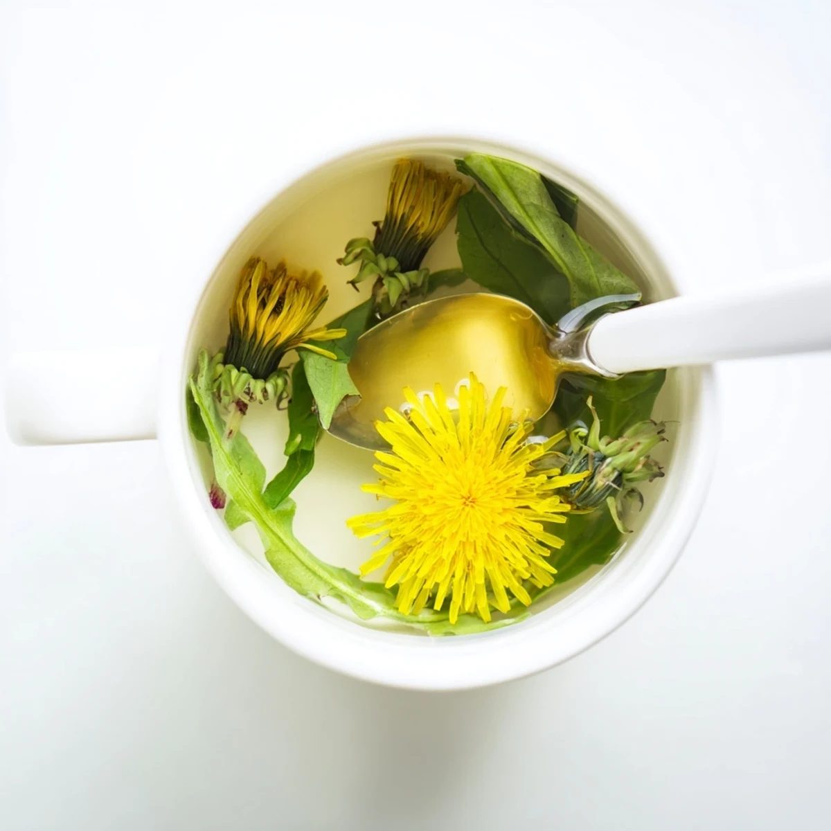 Golden dandelion tea steaming in a white ceramic mug with fresh flowers