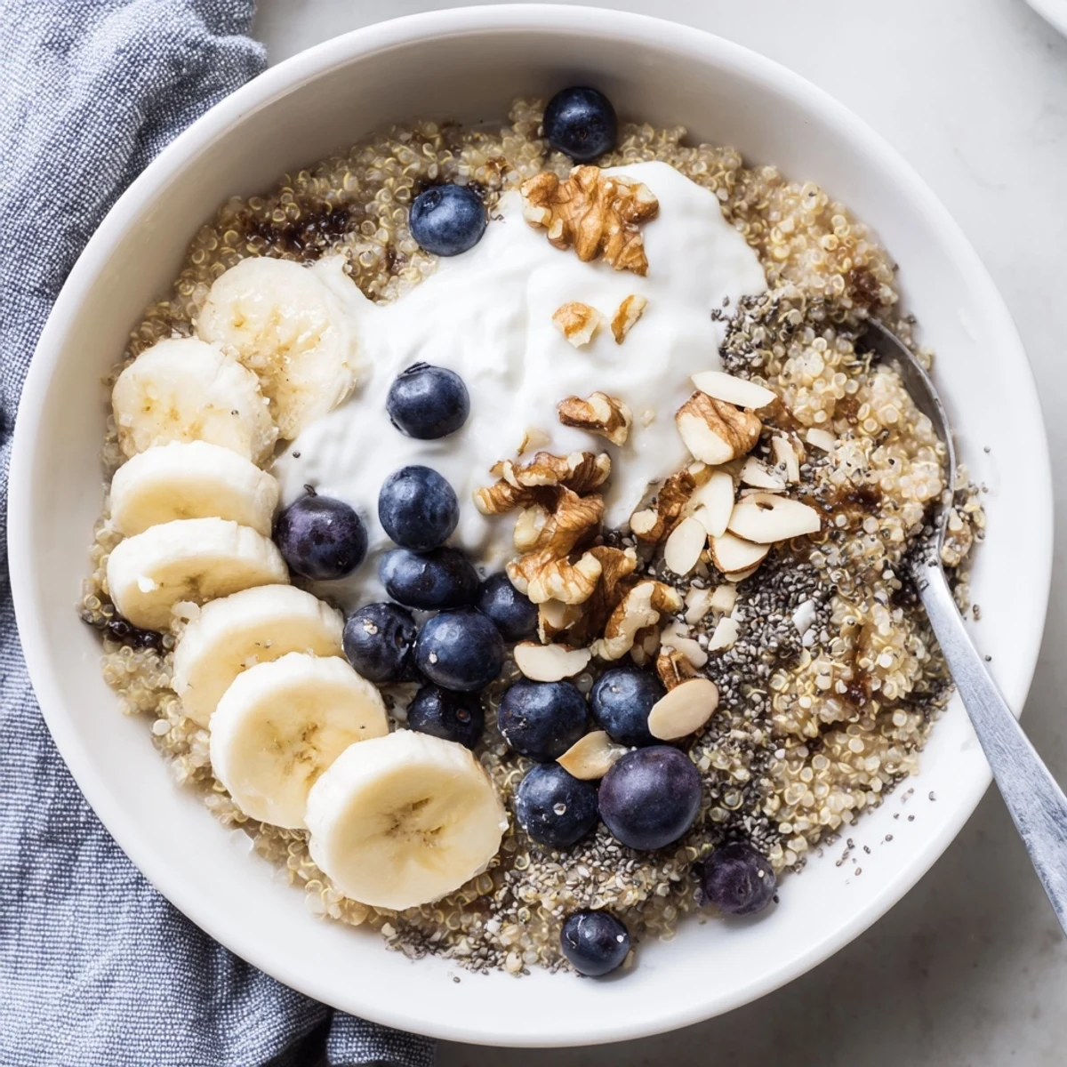 Protein-packed blueberry quinoa breakfast bowl with Greek yogurt, ripe blueberries, and sweet maple drizzle