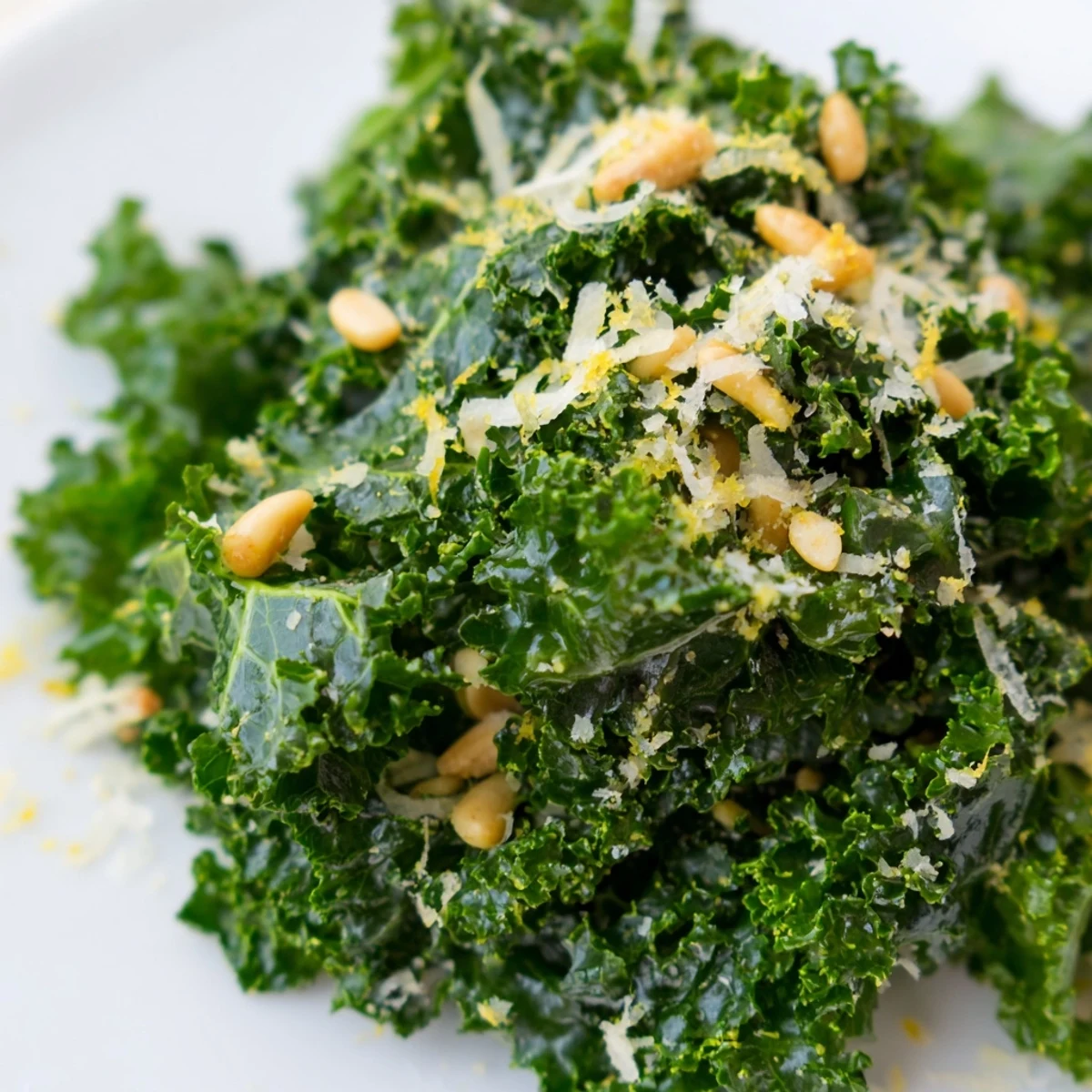 Crisp garlic lemon parmesan kale salad with shaved cheese and toasted pine nuts