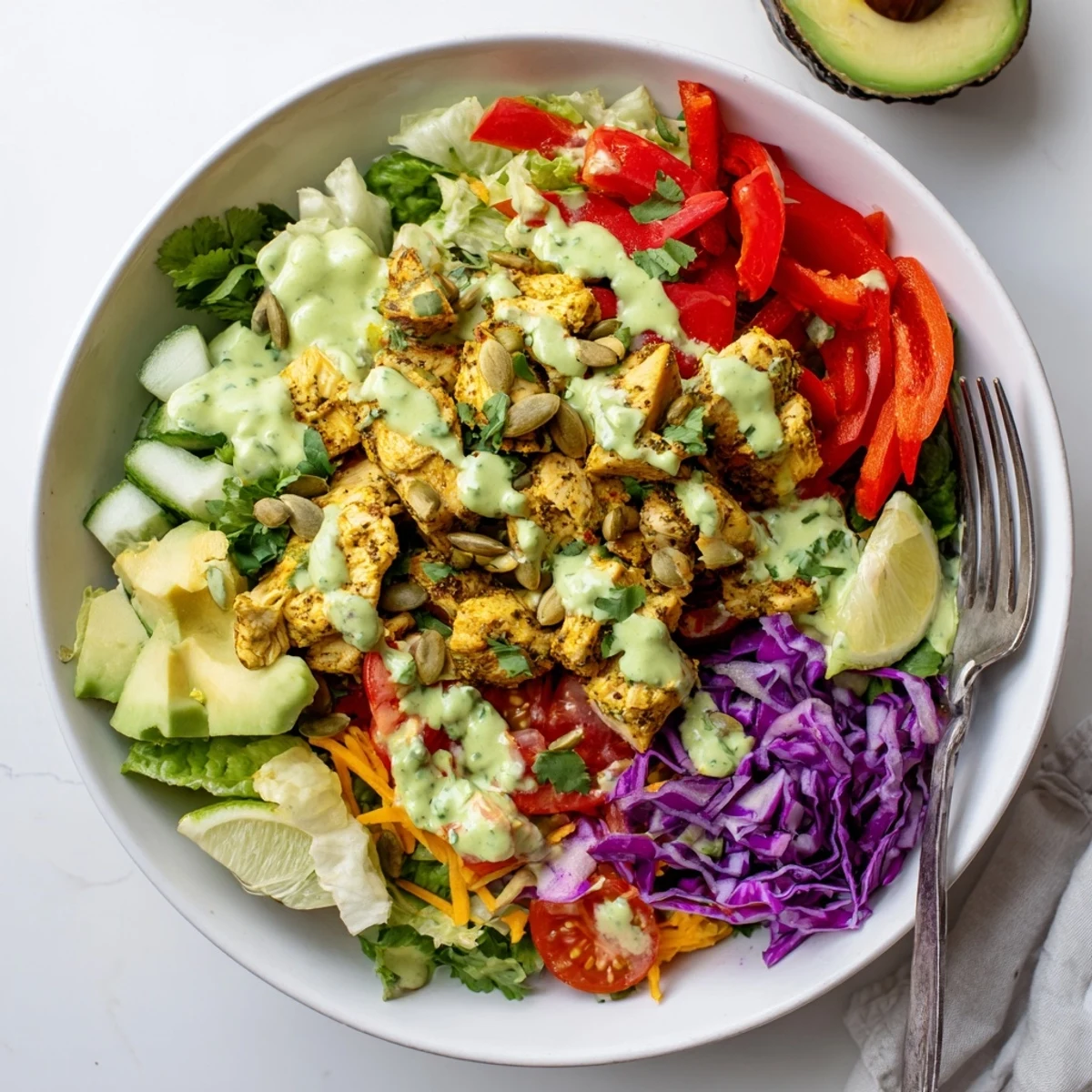 Colorful keto bowls loaded with fresh vegetables, seasoned chicken, and creamy avocado dressing