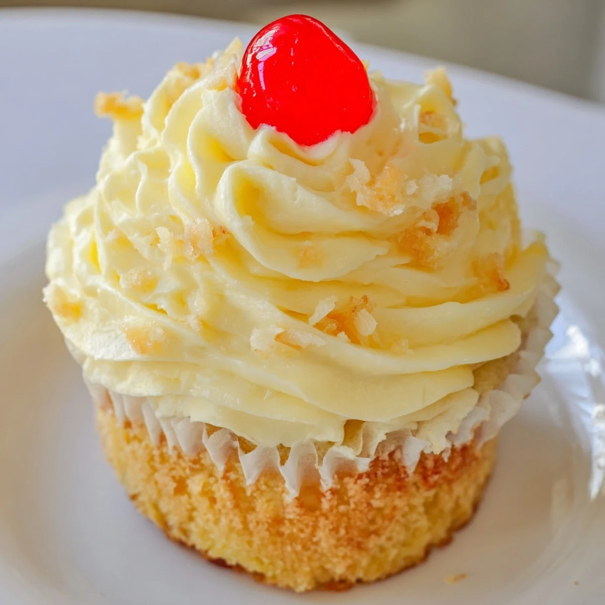 Moist pineapple Dole Whip Cupcakes with creamy yellow frosting piped on a platter