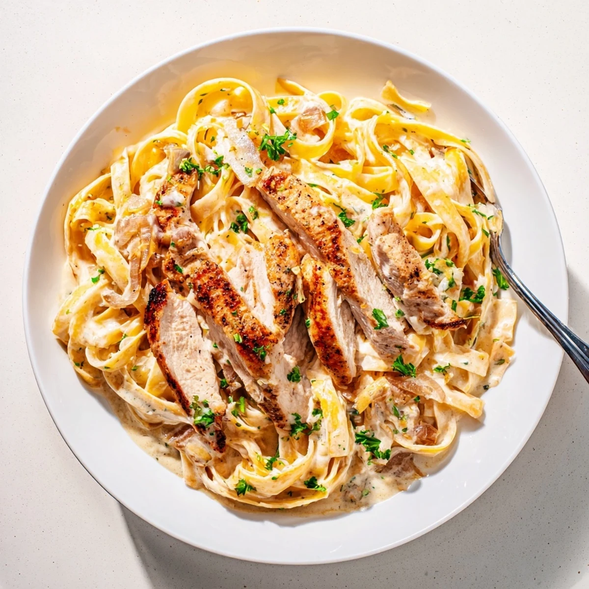 Warm Creamy Garlic Chicken Pasta tossed with sliced seared chicken, fragrant garlic.