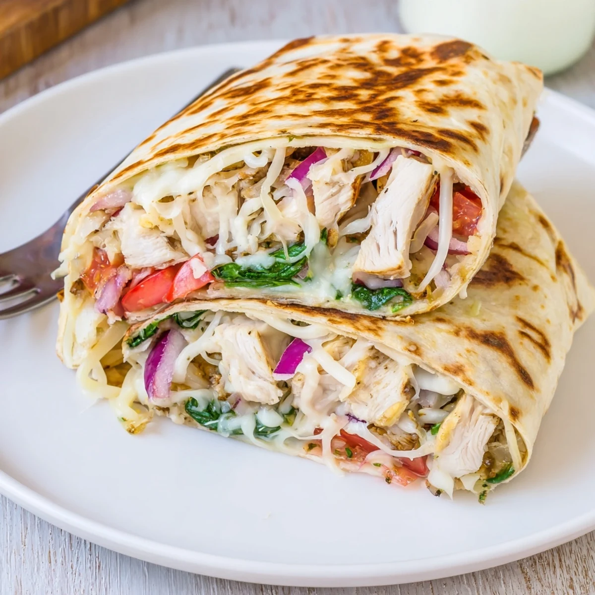 Handheld Cozy Cheesy Garlic Chicken Wraps with tender garlic chicken and gooey cheddar