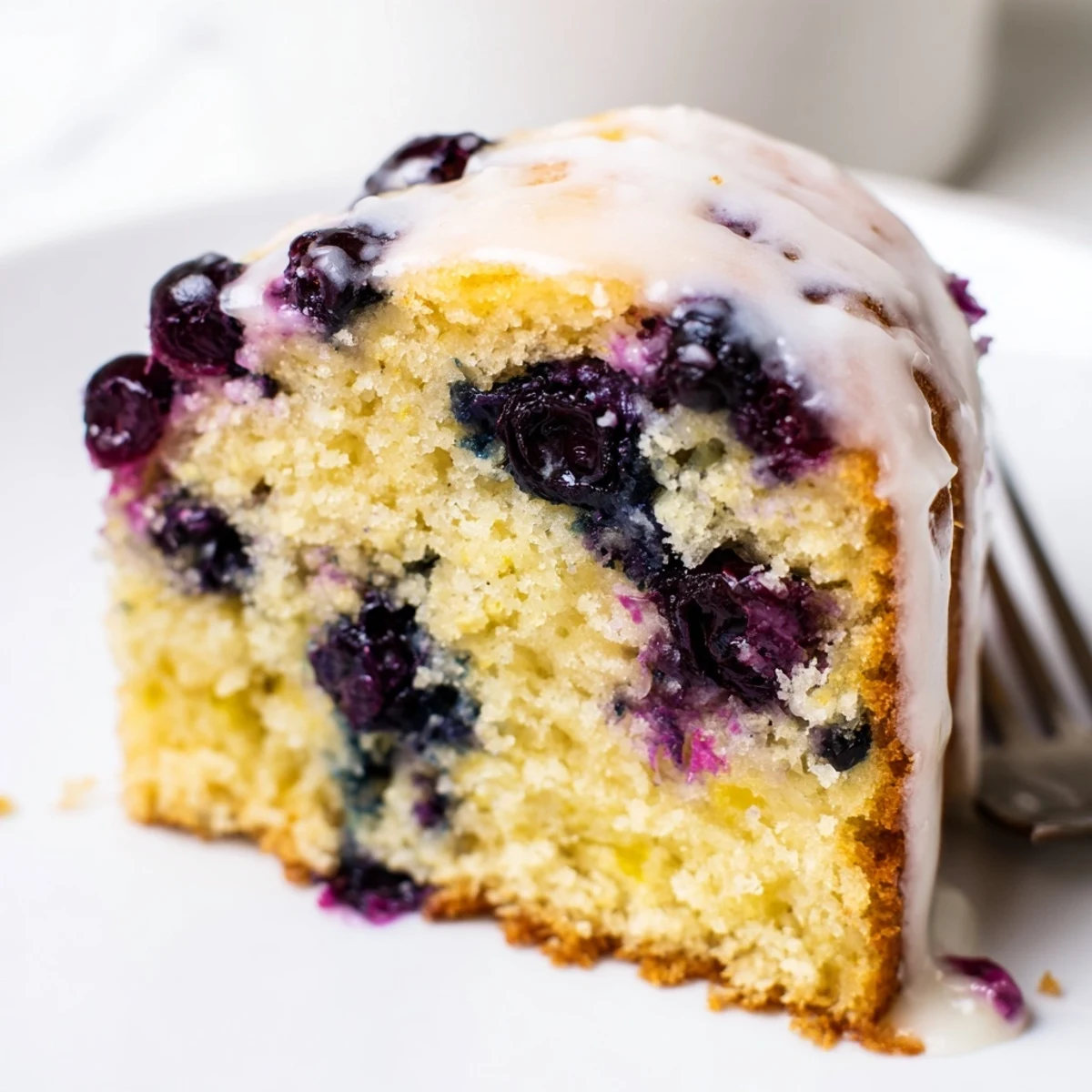 Homemade lemon blueberry cake with vibrant blueberries baked inside and sweet lemon glaze