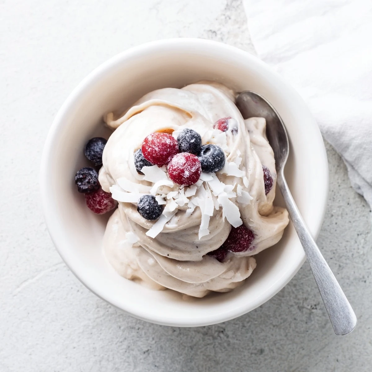 Vegan banana nice cream recipe scooped into dessert bowls with dark chocolate chips and chopped nuts