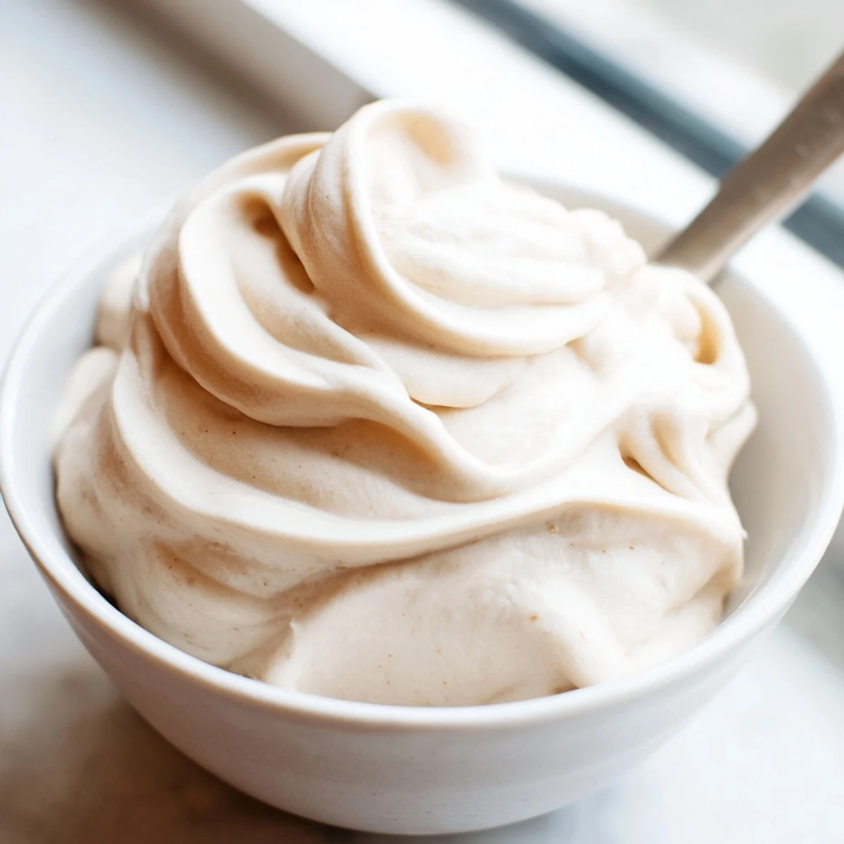 Creamy banana nice cream recipe scooped into bowls topped with fresh banana slices and a sprinkle of cinnamon