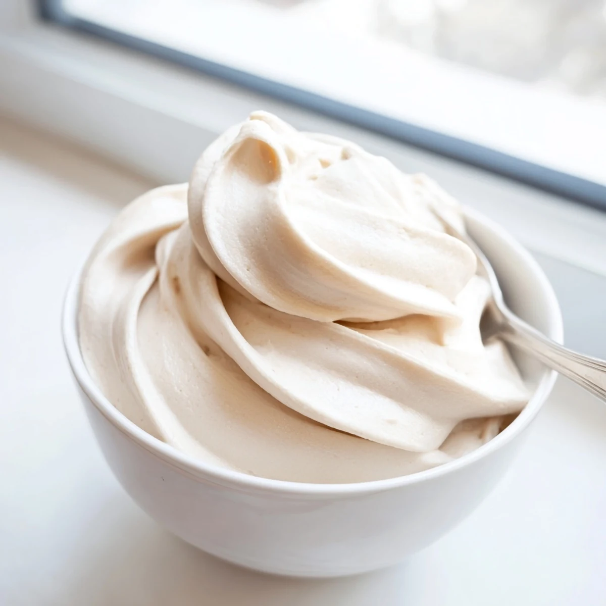 Glossy swirl of dairy-free banana nice cream recipe garnished with dark chocolate shavings and walnuts