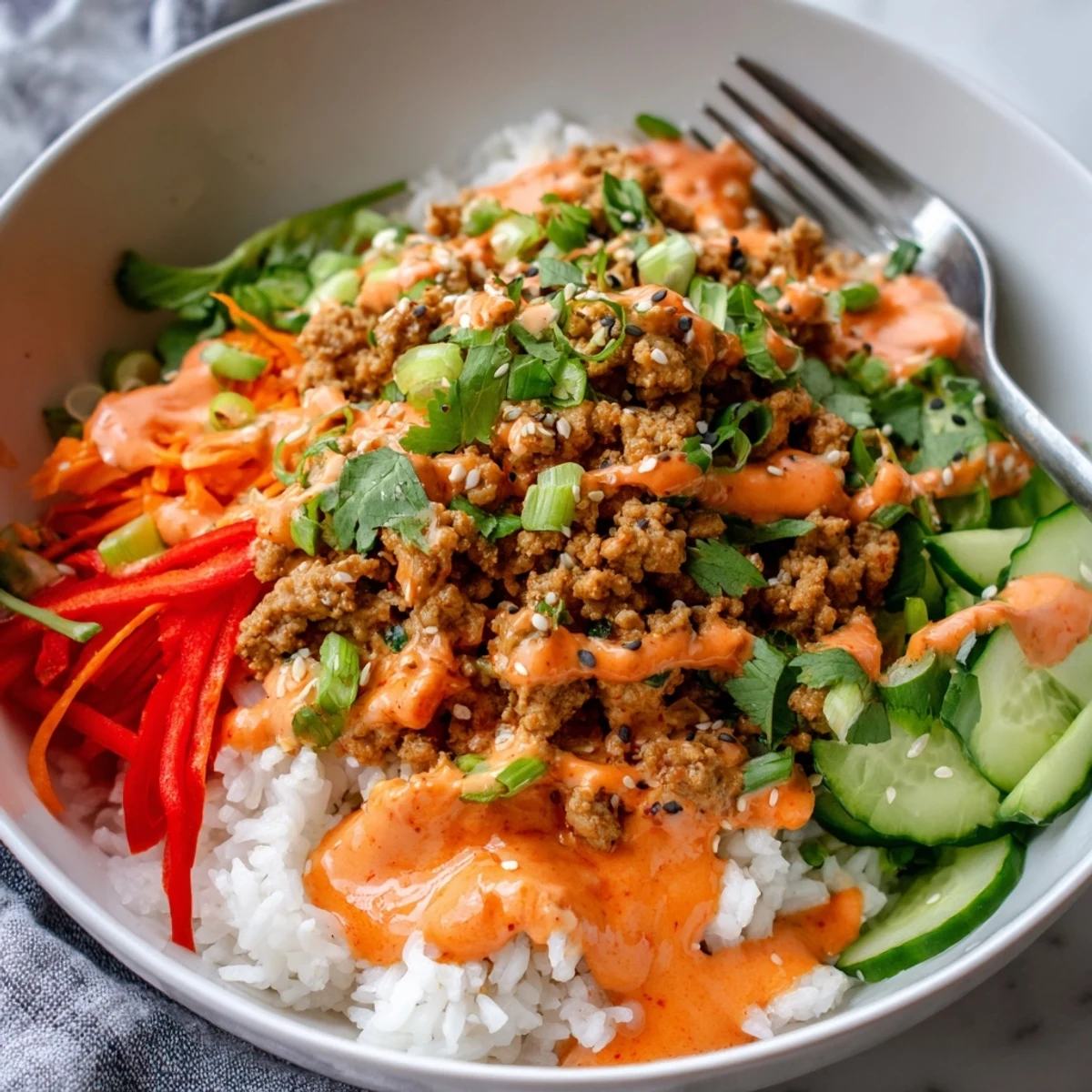 Hearty ground turkey rice bowls drizzled with spicy, creamy Bang Bang sauce and crisp vegetables
