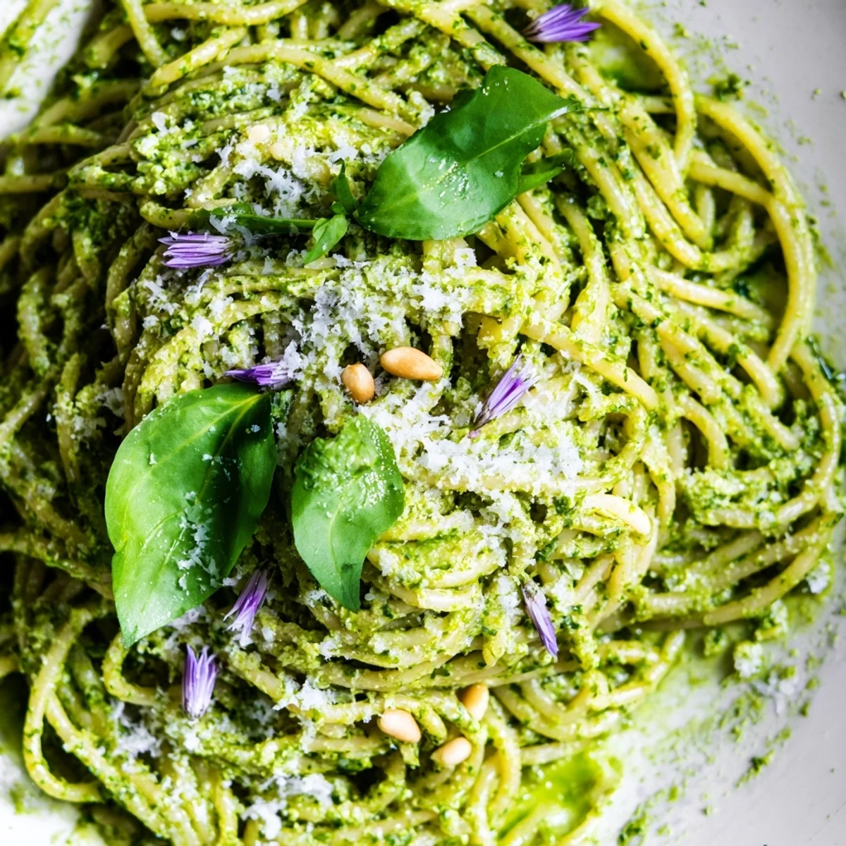 Bright green wild garlic pesto pasta twirled on a fork with shaved Parmesan