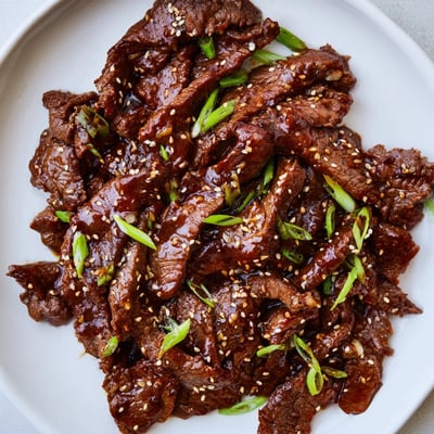 Sliced flank steak coated in a rich ginger and garlic sauce for Ultimate Slow Cooker Mongolian Beef.