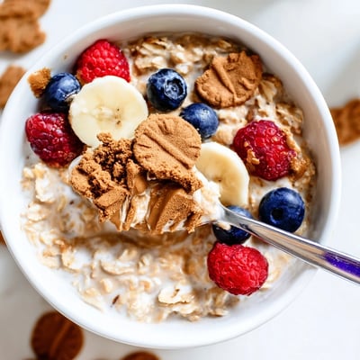 A chilled, creamy breakfast bowl featuring Quick Biscoff Overnight Oats with a maple drizzle.  