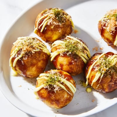 Savory Japanese takoyaki arranged on a wooden board sprinkled with green onions and mayonnaise