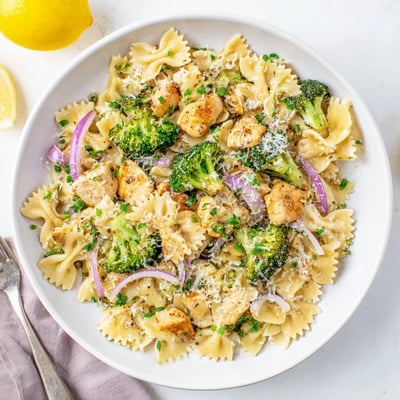 Creamy cowboy butter lemon chicken pasta bowl featuring bowties, fresh broccoli, and golden brown chicken pieces