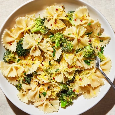Golden ribbons of mafaldine limone broccoli pasta topped with shaved Parmesan cheese